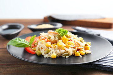 Plate with brown rice and vegetables on wooden table