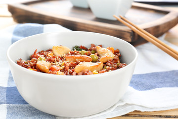 Bowl with tasty brown rice and vegetables, close up