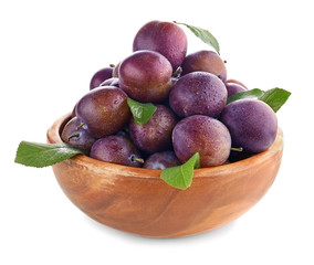 Bowl with ripe plums on white background