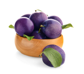 Bowl with ripe plums on white background