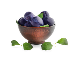 Bowl with ripe plums on white background