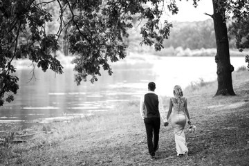 Fototapeta premium Stylish couple of happy newlyweds posing in the park on their wedding day. Perfect couple bride, groom posing and kissing.black and white.