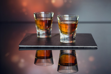 Cognac or liqueur, coffee beans and spices on a glass table.