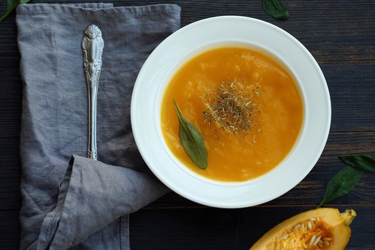 Delicious pumpkin soup with autumn herbs on the table