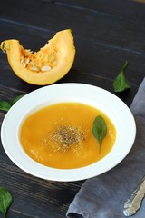 Delicious pumpkin soup with autumn herbs on the table