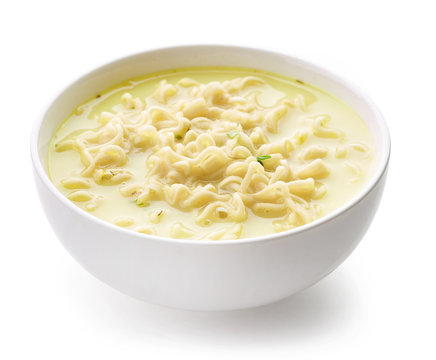Bowl of noodle soup with cheese and herbs