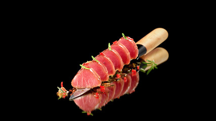Tuna steak in oil with chilli and rosemary served on knife