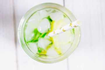 Fototapeta na wymiar Sassy diet water. Cucumber, lemon, mint lemonade in glasses on white wooden table. Top view. Selective focus