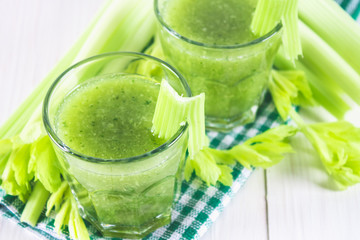 Vegetable cocktail made from celery leaves, healthy lifestyle on a white wooden background.