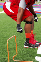 Fototapeta premium Football lineman jumping over mini hurdles