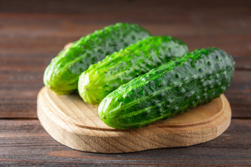 Fresh raw green cucumbers on a wooden table