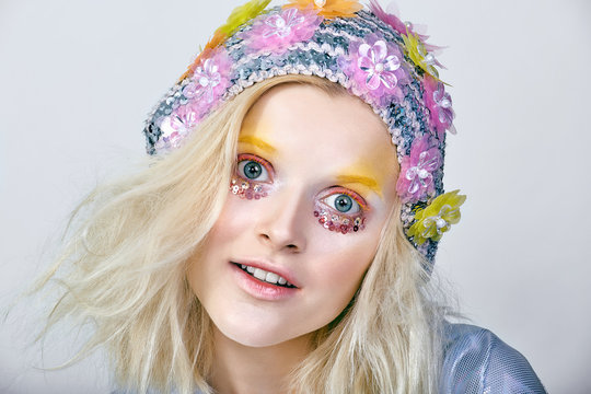 Young girl with colorfull makeup in sparkling hat