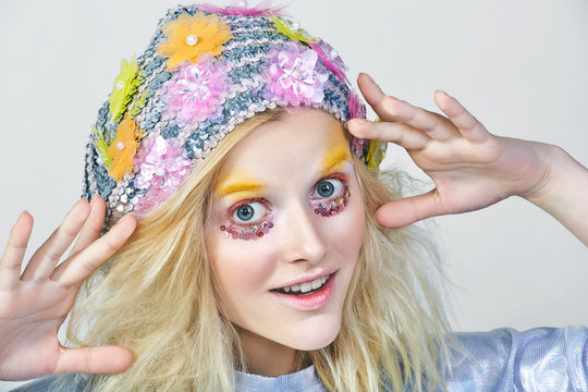Young girl with colorfull makeup in sparkling hat