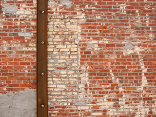 Multicolor brick wall with rusted metal beam and bolts