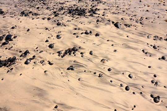 Black stones on a sandy beach