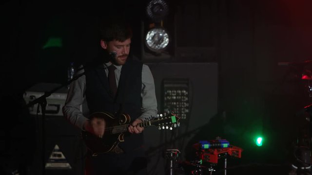  Band performing live on stage at with musician playing the mandolin