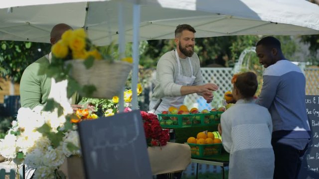  Friendly stall holders selling to customers at a farmers market