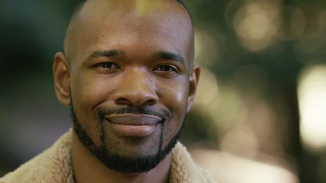 Portrait of attractive black male smiling to camera, in slow motion