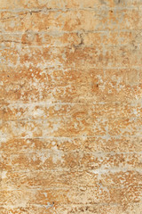 Weathered orange plaster over block wall
