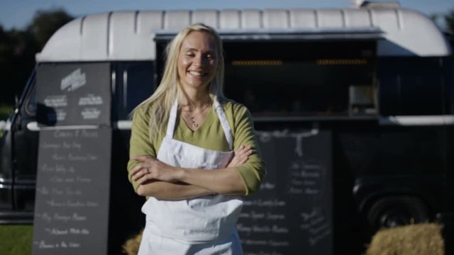  Portrait smiling street food trader standing outside burger van