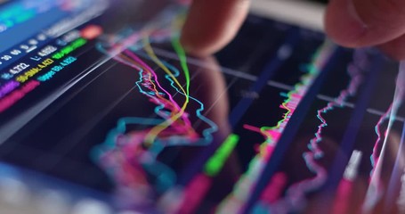 Use of digital tablet computer with stock market graph - Powered by Adobe