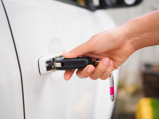 Closeup woman hand holding the remote control car alarm systems.