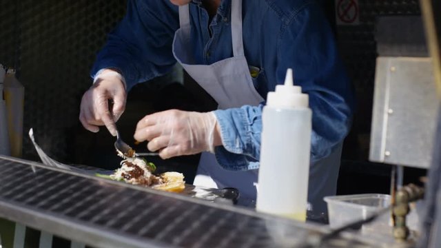  Street food vendor making hot meat snacks for customers at summer festival