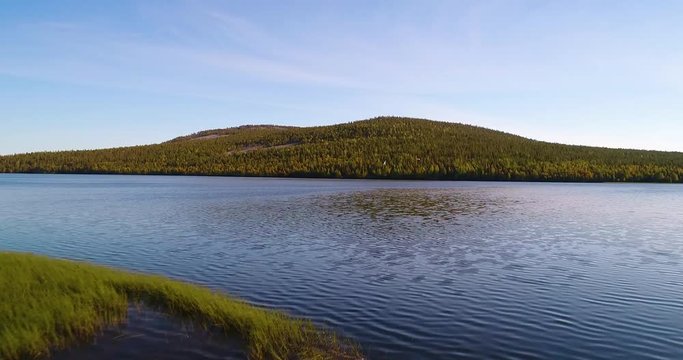 Mountain behind a lake, Cinema 4k aerial view of a flight above pyhajarvi lake, towards a fjeld, in the taiga wilderess of Lapland, in Finland