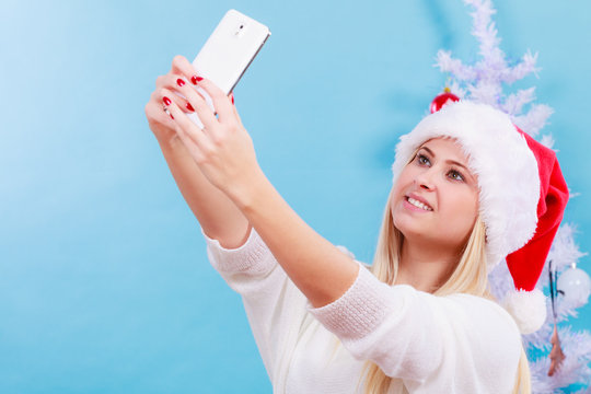 Woman in santa hat taking selfie