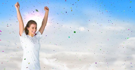 Woman cheering against sunny sky and confetti