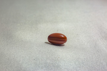 One pill on a white background with fabric texture shot in studio