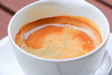 coffee espresso in white cup close up on wood background