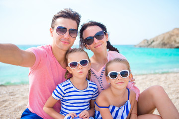 Young beautiful family taking selfie on the beach