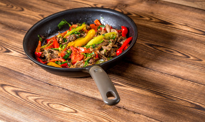Stir frying beef with sweet peppers and green beans. Top view