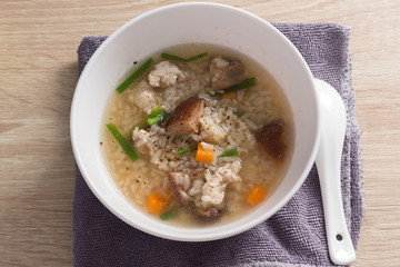 Asian congee with pork in white bowl.