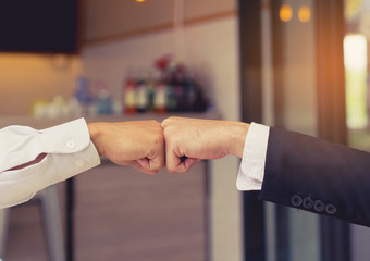 Closeup, Giving fist bump hands of businessmen together teamwork partner and join group successul...