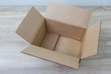 Opened cardboard box on wooden background