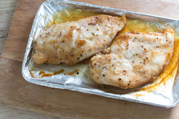 Slices of roasted chicken breast on wooden table, top view