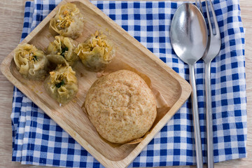 Chinese dumpling and steamed stuff bun on table