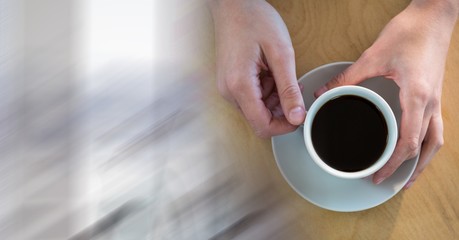 Overhead of hands with coffee cup and blurry white transition