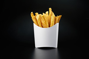 French fries in a white paper box isolated on black background. Front view.