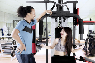 Woman and man laugh together in gym