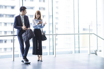 Business couple are eagerly conversing at the window