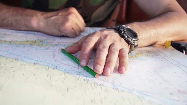 A man chooses a route on the sea map
