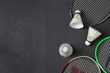 Shuttlecocks and badminton racket on black background.