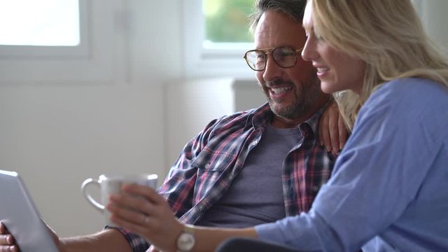 Mature couple connected on internet with laptop