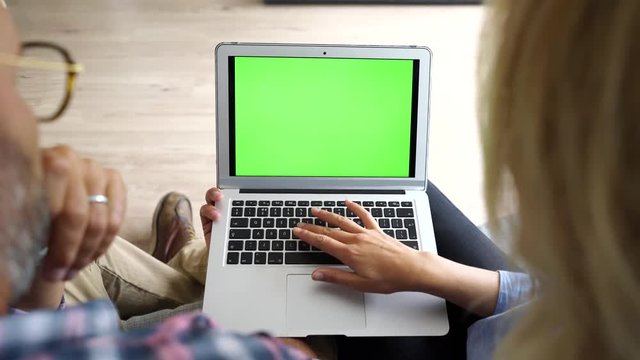 Upper view of couple in sofa using laptop computer
