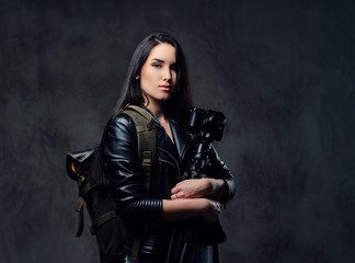 Naklejka premium Brunette female photographer holds professional camera on a tripod.