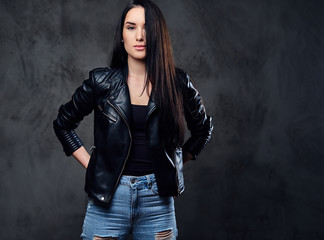 A fashionable brunette female dressed in a black leather jacket.