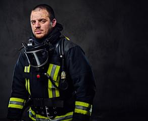 Fototapeta premium Studio portrait of a male dressed in a firefighter uniform.